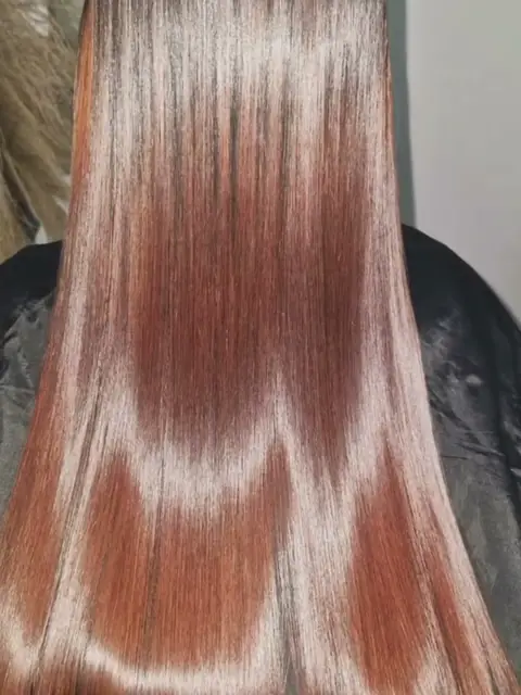 Resultado: cabello cobrizo, largo, liso y con brillo, visto de espaldas