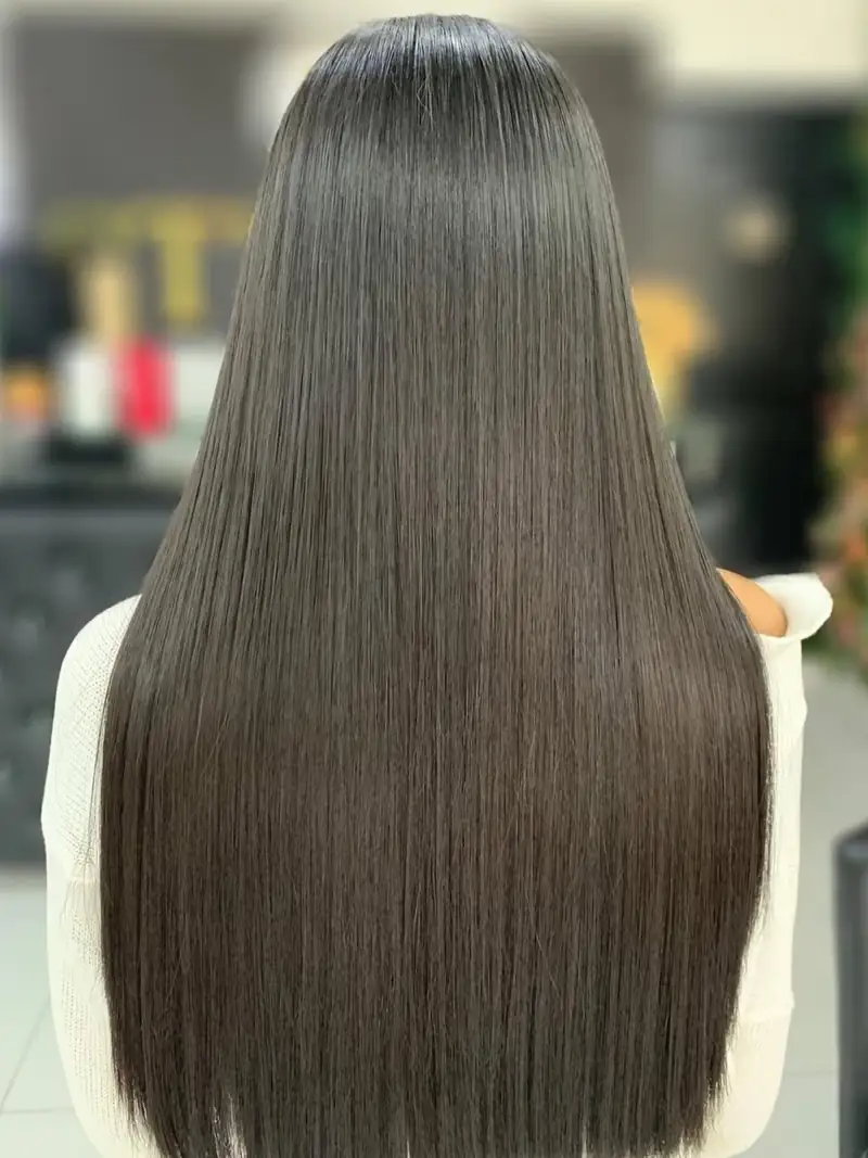 Cabello negro, largo y liso, visto de espaldas, en el salón